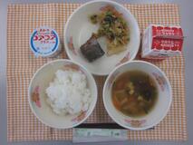 テーブルクロスに並べられたごはん・牛乳・若竹汁・かつおのおかか煮・ごまあえ・ヨーグルトの写真