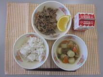 テーブルクロスに並べられた麦ごはん・牛乳・じゃがいもだんご汁・ぶた肉丼・あまなつみかんの写真