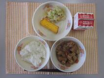 テーブルクロスに並べられたごはん・牛乳・生揚げのみそ煮・厚焼きたまご・三色炒めの写真