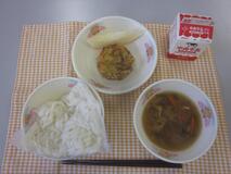 テーブルクロスに並べられた白玉うどん・牛乳・山菜うどん・かき揚げ・メロンの写真