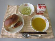 テーブルクロスに並べられたりんごパン・牛乳・米粉のパンプキンポタージュ・揚げどりのレモンソースかけ・キャベツソテーの写真
