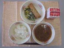 テーブルクロスに並べられたごはん・牛乳・ユッケジャンスープ・はるまき・海そうサラダ・塩中華ドレッシングの写真