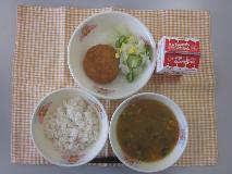 テーブルクロスに並べられた麦ごはん・牛乳・とうがんのカレースープ・さといもコロッケ・やさいサラダ・コーンドレッシングの写真