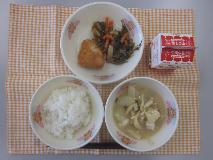 テーブルクロスに並べられたごはん・牛乳・白みそ汁・とり肉の風味揚げ・糸切りこんぶの煮付けの写真