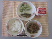 テーブルクロスに並べられたごはん・牛乳・五目きんぴら・いわしのうめ煮・青菜あえの写真
