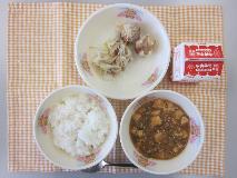テーブルクロスに並べられたごはん・牛乳・マーボーどうふ・しゅうまい・ボイルもやし・パックしょうゆの写真