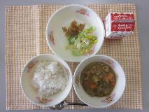 テーブルクロスに並べられた麦ごはん・牛乳・米粉のカレーライス・コーンサラダ・福神漬・コーンドレッシングの写真