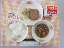 テーブルクロスに並べられたごはん・牛乳・のっぺい汁・れんこんハンバーグ・やさい炒め・お米のみかんババロアの写真