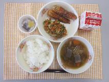 テーブルクロスに並べられたごはん・牛乳・いなか汁・ちくわの青じそ揚げ・ごまあえ・なっとうの写真