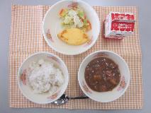 テーブルクロスに並べられた麦ごはん・牛乳・米粉のハヤシライス・オムレツ・コールスローサラダ・コールスロードレッシングの写真