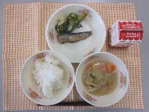 テーブルクロスに並べられたごはん・牛乳・白みそ汁・いわしのうめ煮・きゅうりの塩こんぶあえの写真