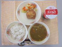 テーブルクロスに並べられた麦ごはん・はっこう乳・米粉のカレースープ・フライドチキン・やさいソテーの写真