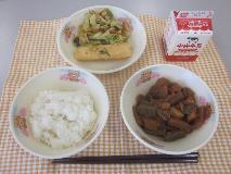 テーブルクロスに並べられたごはん・牛乳・煮みそ・いかの天ぷら・ごまあえの写真