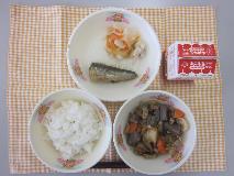 テーブルクロスに並べられたごはん・牛乳・いりどり・いわしのしょうが煮・三色なますの写真