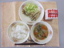 テーブルクロスに並べられたごはん・牛乳・肉だんごとはくさいのスープ・わかさぎのから揚げ・ボイルキャベツ・パックソースの写真