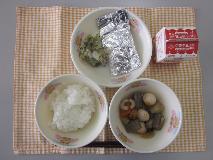 テーブルクロスに並べられたごはん・牛乳・おでん・たらの銀紙焼き・赤しそあえの写真