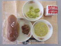 テーブルクロスに並べられた愛知の米粉入りパン・牛乳・米粉のコーンクリームスープ・とり肉のトマトソースかけ・キャベツソテーの写真