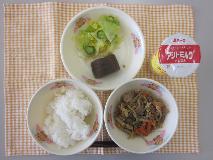 テーブルクロスに並べられたごはん・はっこう乳・五目きんぴら・かつおのおかか煮・しんこあえの写真