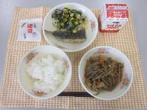 テーブルクロスに並べられたごはん・牛乳・五目きんぴら・いわしのかば焼き丼・海そうサラダ・せつぶん豆・塩中華ドレッシングの写真