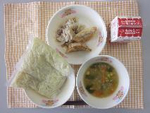 テーブルクロスに並べられた中華めん・牛乳・とんこつしょうゆラーメン・ぎょうざ・ ボイルもやし・パックしょうゆの写真