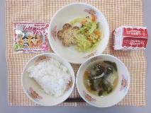 テーブルクロスに並べられたごはん・牛乳・白みそ汁・花型とうふハンバーグ・やさいソテー・ひなあられの写真