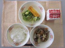 テーブルクロスに並べられたごはん・牛乳・煮しめ・厚焼きたまご・きゅうりあえの写真