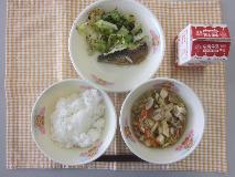 テーブルクロスに並べられたごはん・牛乳・肉どうふ・いわしのしょうが煮・赤しそあえの写真