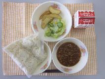 テーブルクロスに並べられたソフトめん・牛乳・ミートソース・フライドポテト・フレンチサラダ・フレンチドレッシングの写真