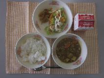 テーブルクロスに並べられたごはん・牛乳・米粉のチキンカレーライス・カラフルサラダ・福神漬・マヨネーズドレッシングの写真