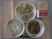 テーブルクロスに並べられた麦ごはん・牛乳・マーボーどうふ・愛知県産食材入りぎょうざ・ボイルもやし・パックしょうゆの写真