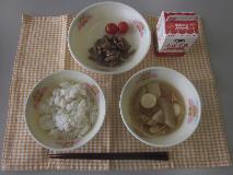 テーブルクロスに並べられた麦ごはん・牛乳・じゃがいもだんご汁・ぶた肉丼・ミニトマトの写真