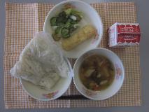 テーブルクロスに並べられた白玉うどん・牛乳・山菜うどん・いかの天ぷら・きゅうりあえの写真