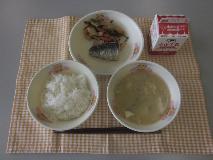 テーブルクロスに並べられたごはん・牛乳・白みそ汁・にしんの塩焼き・くきわかめの煮付けの写真