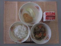 テーブルクロスに並べられたごはん・牛乳・じゃがいものそぼろ煮・うの花はんぺん・メロンの写真