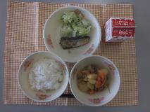 テーブルクロスに並べられたごはん・牛乳・肉じゃが・いわしのうめ煮・青菜あえの写真
