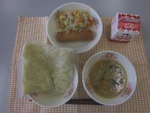 テーブルクロスに並べられた中華めん・牛乳・とんこつしょうゆラーメン・はるまき・三色炒めの写真