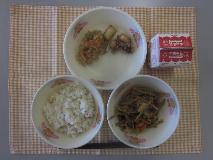 テーブルクロスに並べられた玄米ごはん・牛乳・細切りやさいの炒め煮・たこから揚げ・切り干しだいこんの煮付けの写真