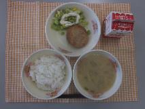 テーブルクロスに並べられたごはん・牛乳・白みそ汁・愛知のおから入りハンバーグ・グリーンアスパラガスのサラダ・マヨネーズドレッシングの写真