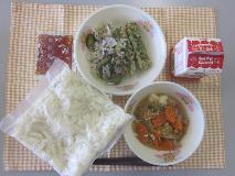 テーブルクロスに並べられた冷やし白玉うどん・牛乳・肉どうふ・ミニちくわのいそべ揚げ・赤しそあえ・うどんつゆの写真