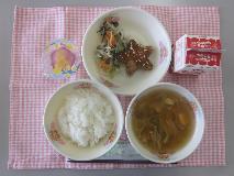 テーブルクロスに並べられたごはん・牛乳・きらきらすまし・ほし型ハンバーグ・三色炒め・たなばたゼリーの写真