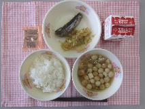 テーブルクロスに並べられたごはん・牛乳・ふ玉汁・いわしのしょうが煮・ごまあえ・コーヒー糖の写真