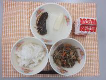 テーブルクロスに並べられたごはん・牛乳・五目きんぴら・いわしのみそ煮・なしの写真