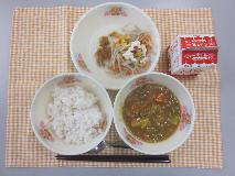 テーブルクロスに並べられた麦ごはん・牛乳・米粉のカレーライス・ごぼうサラダ・福神漬・マヨネーズドレッシングの写真