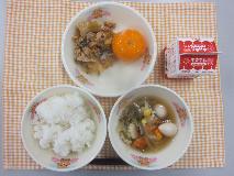 テーブルクロスに並べられたごはん・牛乳・うずらたまごスープ・ぶたキムチ丼・冷凍みかんの写真