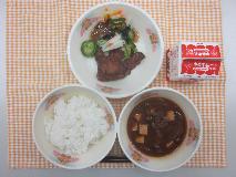 テーブルクロスに並べられたごはん・牛乳・なめこ汁・ぶりの竜田揚げ・和風サラダ・和風ドレッシングの写真