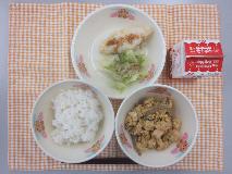 テーブルクロスに並べられたごはん・牛乳・生揚げのたまごとじ・米粉のほきフライ・ボイルキャベツ・パックソースの写真
