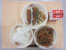 テーブルクロスに並べられたごはん・牛乳・細切りやさいの炒め煮ちくわの青じそ揚げ・ごまあえの写真