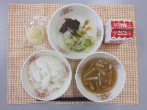 テーブルクロスに並べられたごはん・牛乳・きのこ汁・さばのみそ煮・お好みあえ〔福神漬〕・くりまんじゅうの写真