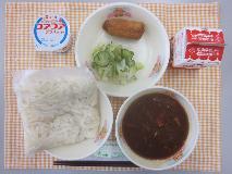 テーブルクロスに並べられた白玉うどん・牛乳・みそ煮込みうどん・いなりずし・青菜あえ・ヨーグルトの写真