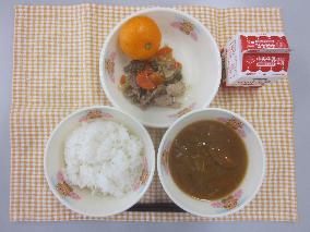 テーブルクロスに並べられたごはん・牛乳・石狩汁・だいこんとぶた肉のスタミナ煮・みかんの写真